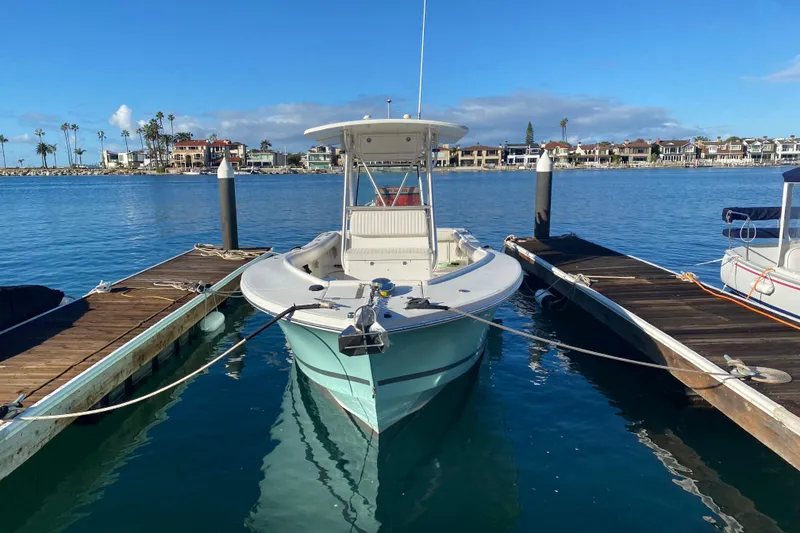 Slide: The Image of 2007 Regulator 26 Forward Seating boat docked in a scenic marina. - 2