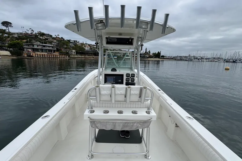 Slide: The Image of 2007 Regulator 26 Forward Seating boat on calm water near a marina. - 7