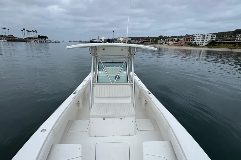 Slide: The Image of 2007 Regulator 26 Forward Seating boat on calm water near a coastal town. - 18