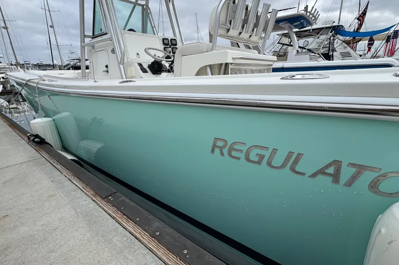 Slide: The Image of 2007 Regulator 26 Forward Seating boat docked at marina, side view. - 1