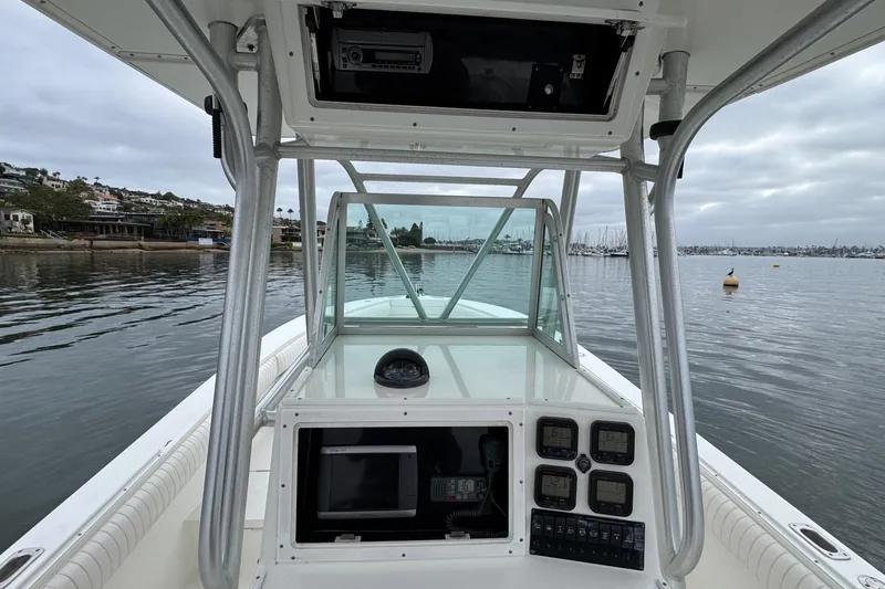 Slide: The Image of 2007 Regulator 26 Forward Seating boat on calm water, featuring a modern control panel. - 12