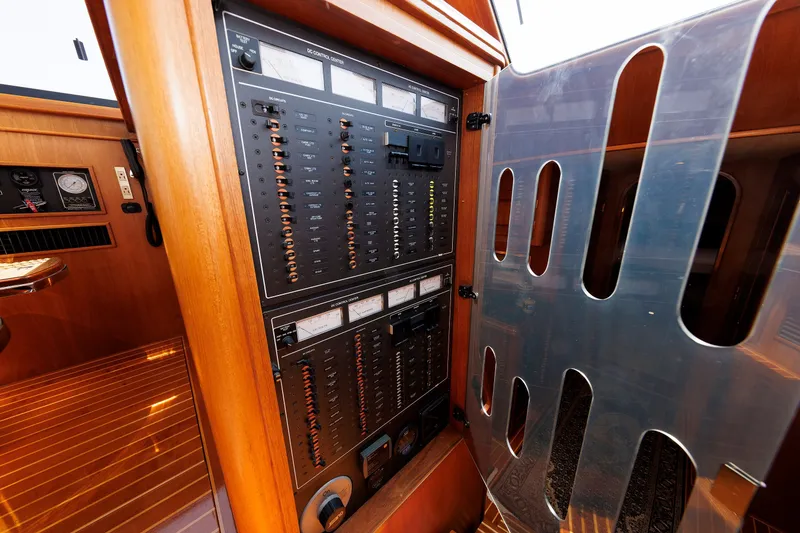 Slide: The Image of Electrical control panel inside 2008 Alden 52 Salon Express yacht, featuring wood finish and gauges. - 18