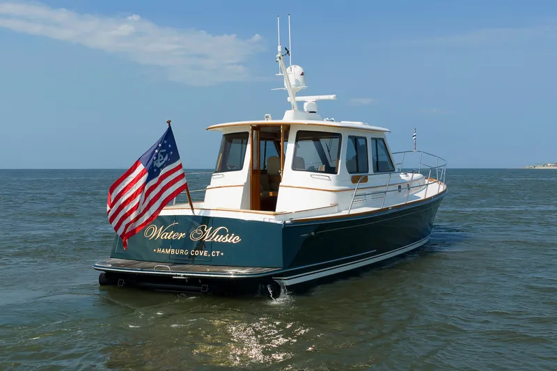 Slide: The Image of Alden 52 Salon Express 2008 boat named "Water Music" on open water with American flag. - 55