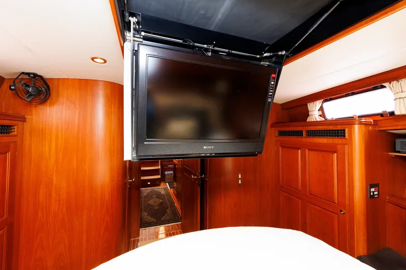 Slide: The Image of Luxurious interior of 2008 Alden 52 Salon Express yacht with mounted TV and wooden cabinetry. - 31