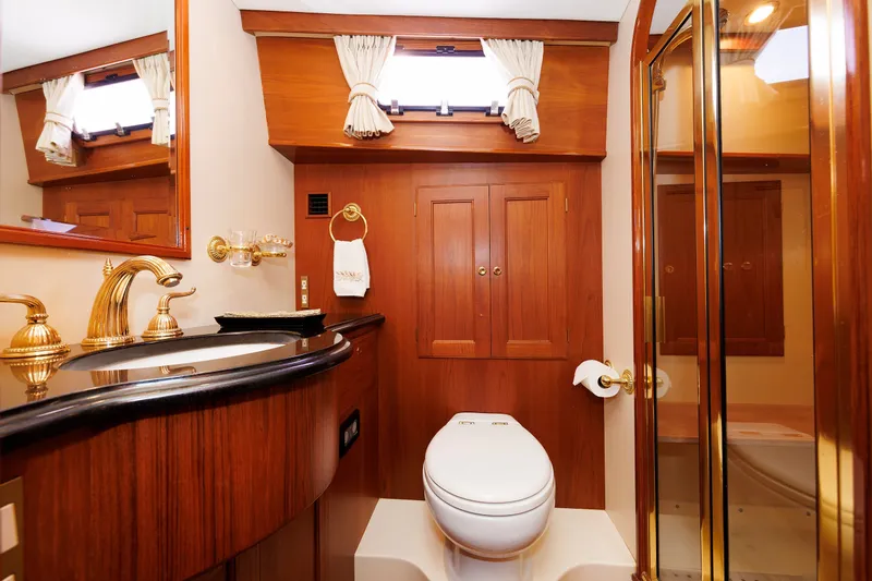 Slide: The Image of Luxurious bathroom in 2008 Alden 52 Salon Express yacht with wood accents and gold fixtures. - 33