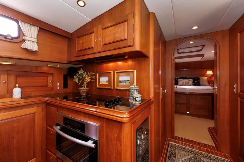 Slide: The Image of Luxurious wooden interior of 2008 Alden 52 Salon Express yacht, featuring a cozy kitchen and bedroom. - 22