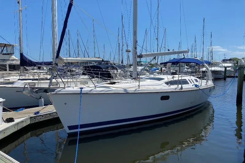 The Image of 1999 Hunter 380 sailboat docked in a marina under clear blue skies. - 0