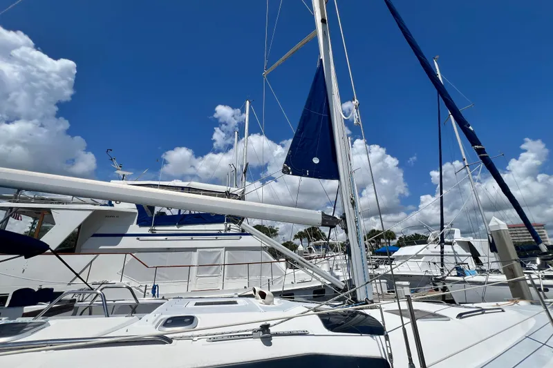 Slide: The Image of Sailboats docked under a clear blue sky, featuring a 1999 Hunter 380 model. - 11