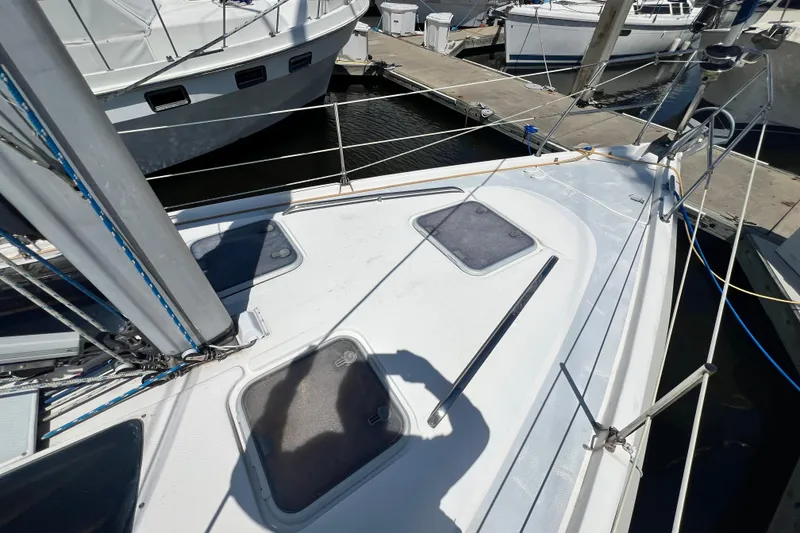 Slide: The Image of Deck view of a 1999 Hunter 380 sailboat docked at a marina. - 12