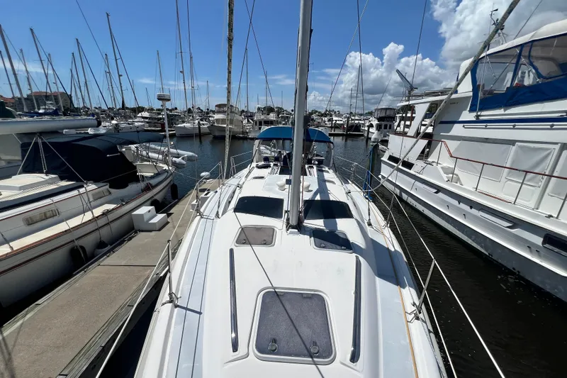 Slide: The Image of 1999 Hunter 380 sailboat docked in a marina, surrounded by other boats. - 14