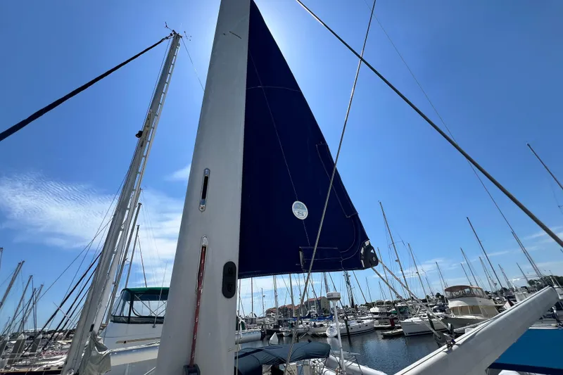 Slide: The Image of Sailboat mast and sail of a 1999 Hunter 380 in a marina under clear blue sky. - 16