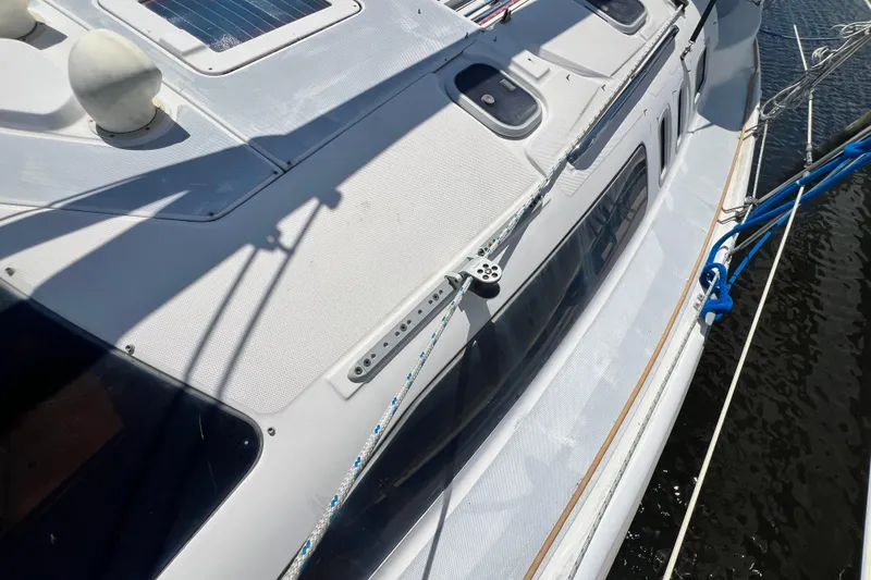 Slide: The Image of 1999 Hunter 380 sailboat deck with rigging and solar panel, docked on calm water. - 19