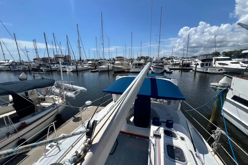 Slide: The Image of Sailboats docked at a marina, featuring a 1999 Hunter 380 under a clear blue sky. - 21