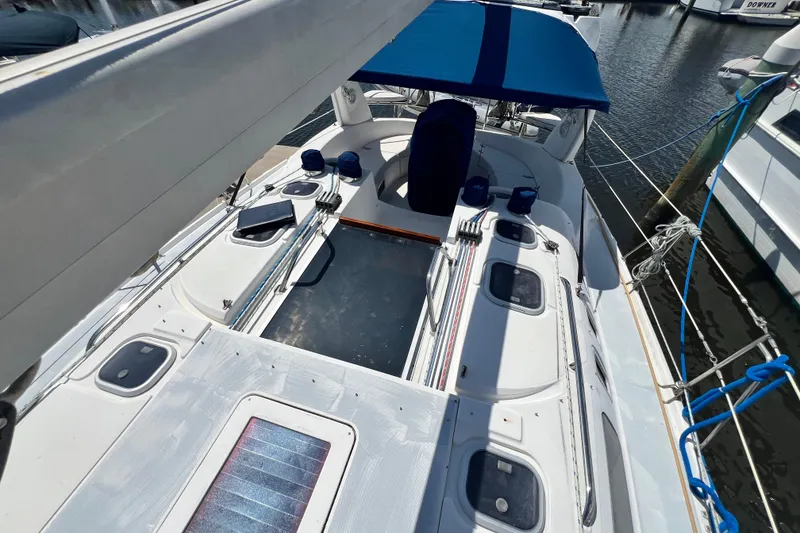 Slide: The Image of 1999 Hunter 380 sailboat deck with blue canopy, docked at marina. - 22