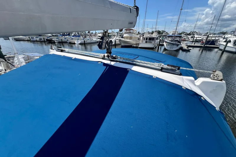 Slide: The Image of Hunter 380 sailboat from 1999 with blue cover docked at marina. - 25