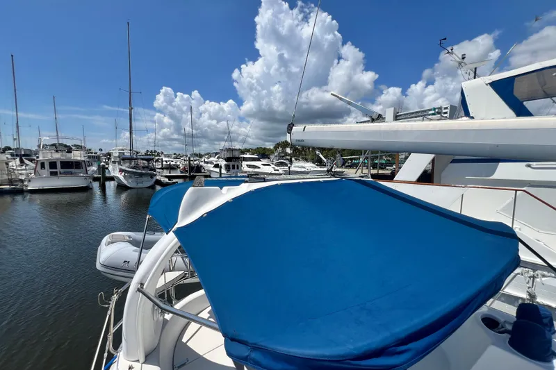 Slide: The Image of Sailboats docked at marina under blue sky, featuring a 1999 Hunter 380. - 26