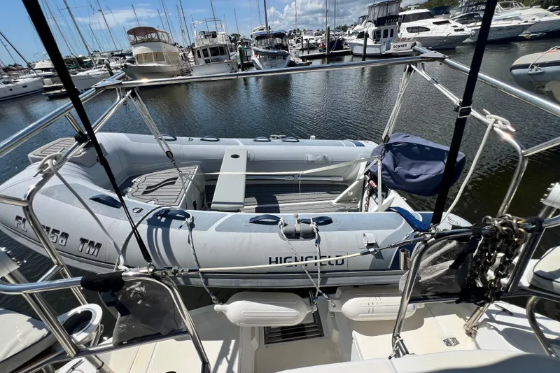 Slide: The Image of Hunter 380 sailboat from 1999 with inflatable dinghy docked at marina. - 28