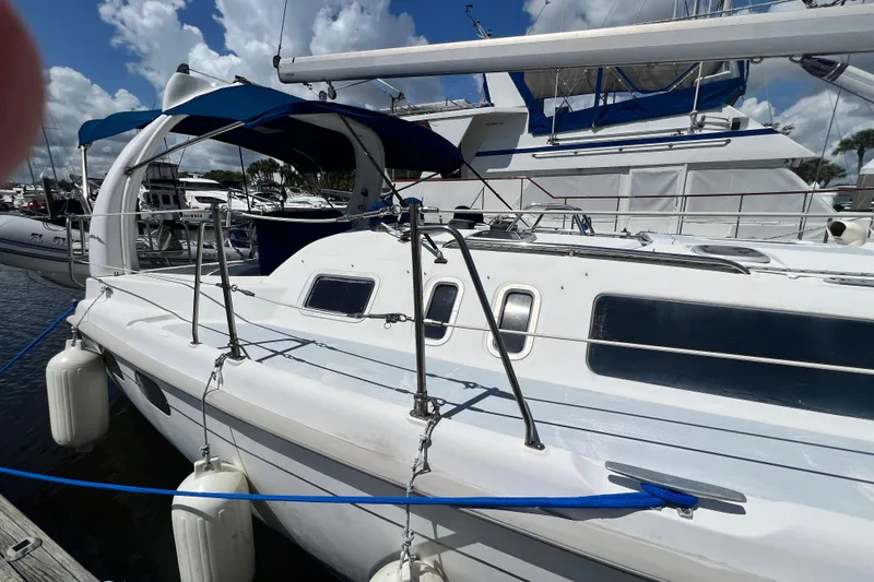 Slide: The Image of 1999 Hunter 380 sailboat docked at marina under blue sky. - 4