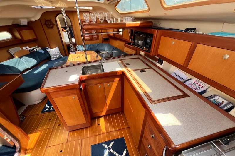 Slide: The Image of Interior of a 1999 Hunter 380 sailboat featuring a cozy kitchen and seating area. - 45