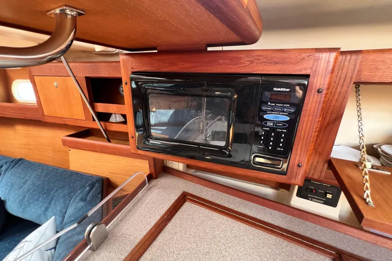 Slide: The Image of Interior of a 1999 Hunter 380 sailboat featuring a built-in microwave in the galley. - 48