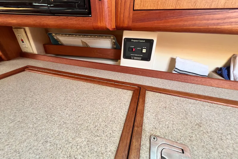 Slide: The Image of 1999 Hunter 380 yacht interior with propane control panel and wooden cabinetry. - 49