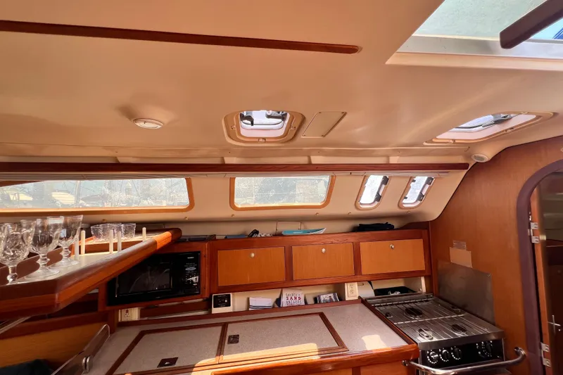 Slide: The Image of Interior of a 1999 Hunter 380 sailboat kitchen with wooden cabinets and appliances. - 50
