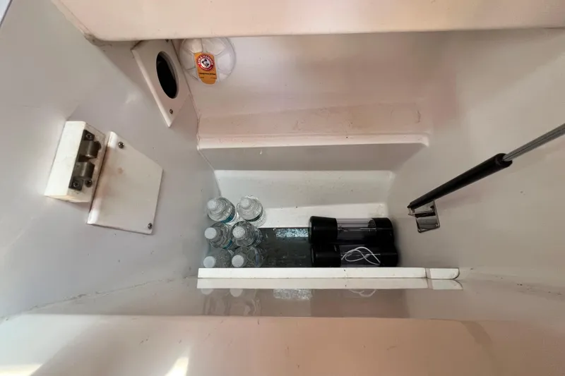 Slide: The Image of Storage compartment in a 1999 Hunter 380 yacht with water bottles and equipment. - 51