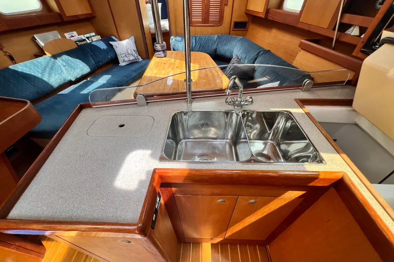 Slide: The Image of Interior of a 1999 Hunter 380 sailboat featuring a kitchen sink and seating area. - 53
