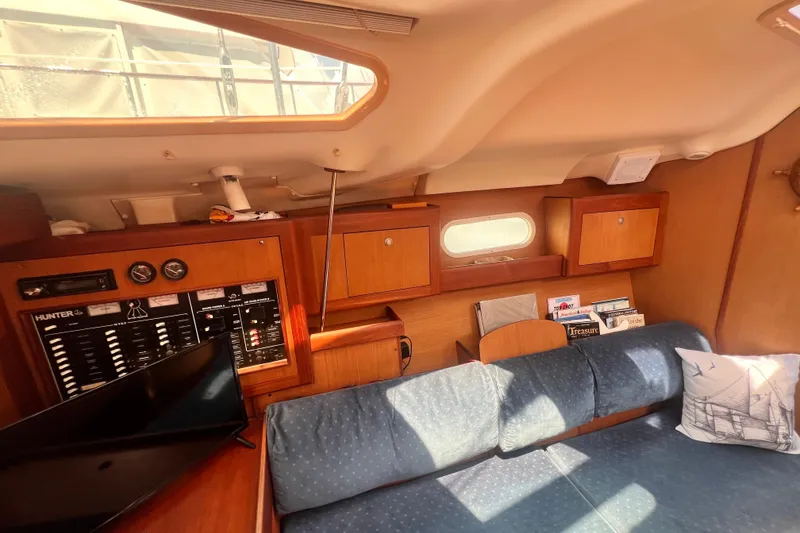 Slide: The Image of Interior of a 1999 Hunter 380 sailboat with cozy seating and wooden cabinetry. - 56
