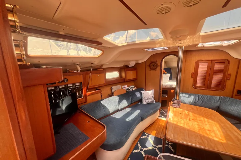 Slide: The Image of Interior of a 1999 Hunter 380 sailboat with cozy seating and wooden finishes. - 59