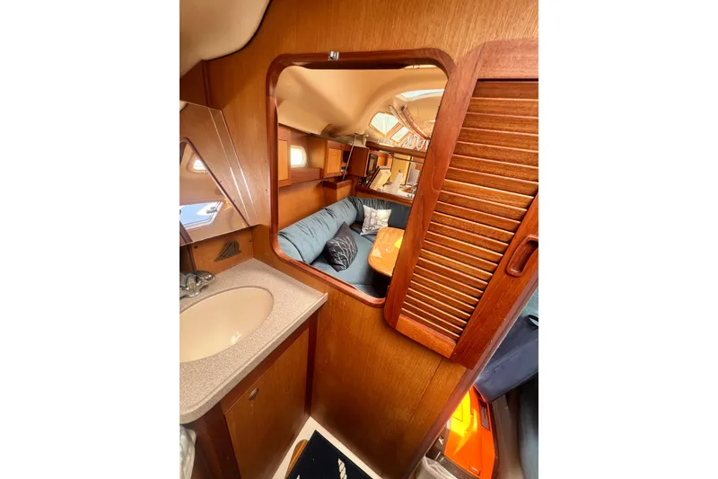 Slide: The Image of Interior of 1999 Hunter 380 sailboat with wooden cabinetry and cozy seating area. - 62