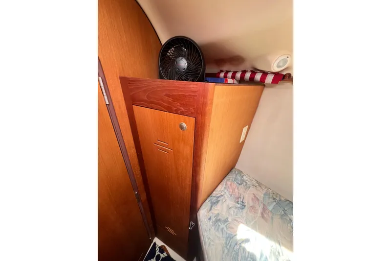 Slide: The Image of Interior of a 1999 Hunter 380 sailboat with wooden cabinetry and a small fan. - 64