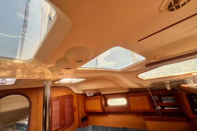 Slide: The Image of Interior view of a 1999 Hunter 380 sailboat cabin with skylights and wooden cabinetry. - 65