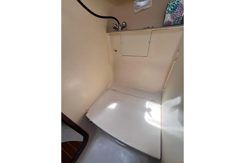 Slide: The Image of Compact bathroom area in a 1999 Hunter 380 sailboat, featuring a shower and sink. - 66