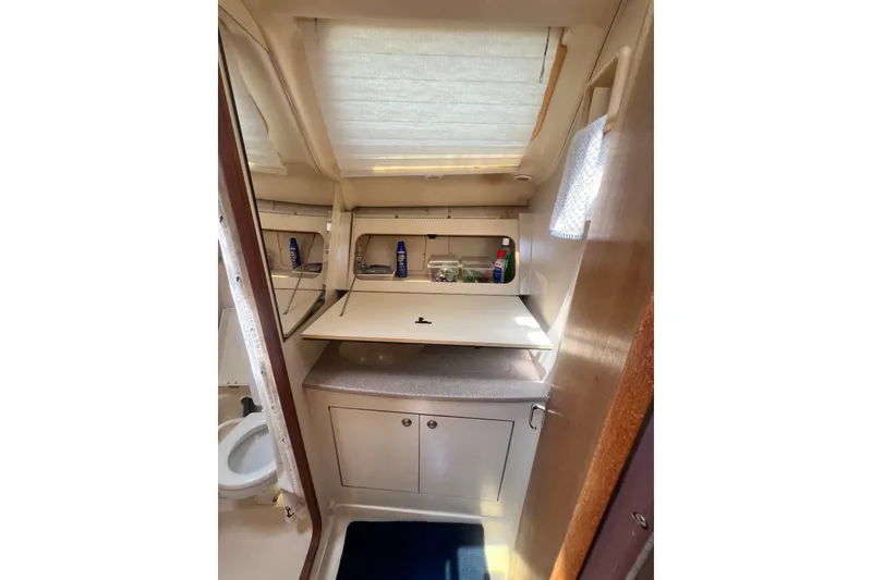 Slide: The Image of Interior of 1999 Hunter 380 sailboat bathroom with sink, storage, and natural light. - 67