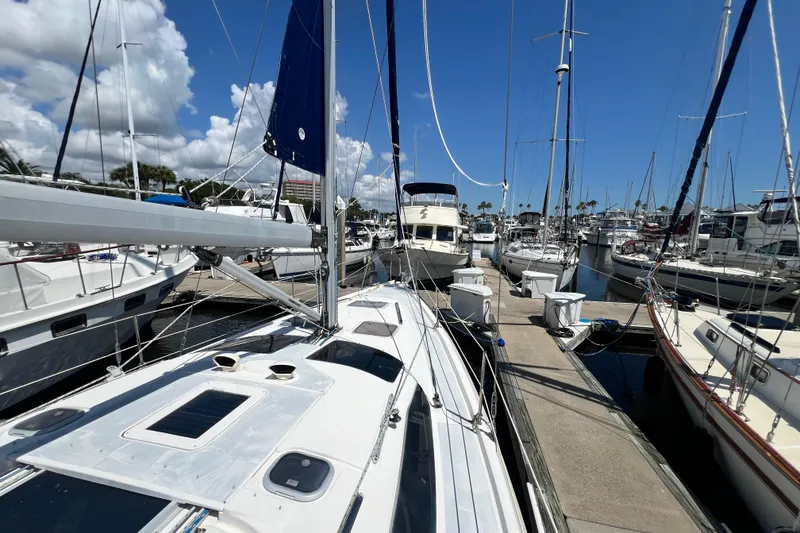 Slide: The Image of Sailboats docked at a marina under a clear blue sky, featuring a 1999 Hunter 380. - 7