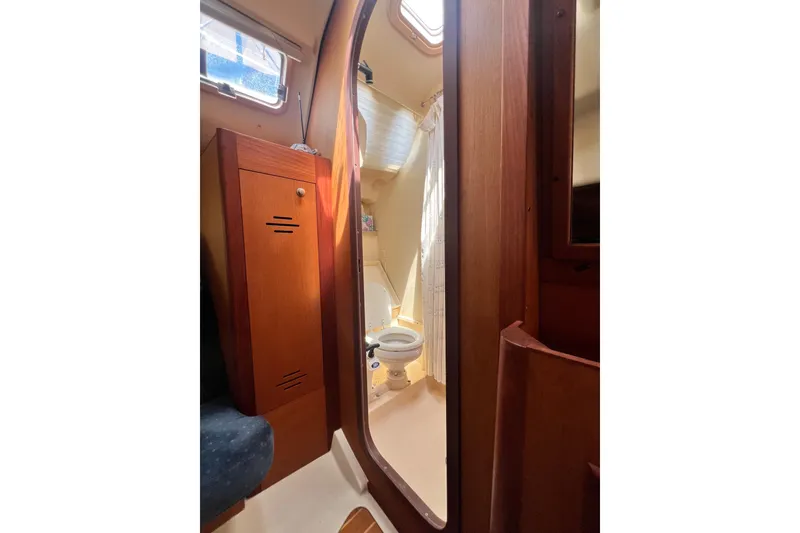 Slide: The Image of Interior of a 1999 Hunter 380 sailboat bathroom with wooden cabinetry and a toilet. - 70