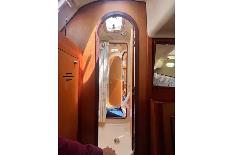 Slide: The Image of Interior view of a 1999 Hunter 380 sailboat cabin with wooden finishes. - 71