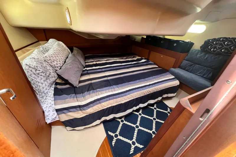 Slide: The Image of Cozy cabin interior of a 1999 Hunter 380 sailboat with striped bedding and nautical decor. - 74