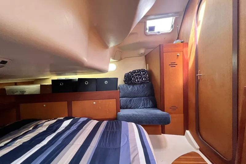 Slide: The Image of Cozy cabin interior of 1999 Hunter 380 sailboat with bed, seating, and storage. - 75