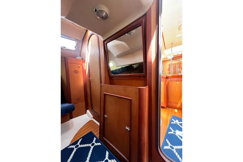 Slide: The Image of Interior of 1999 Hunter 380 sailboat with wooden cabinetry and nautical decor. - 76
