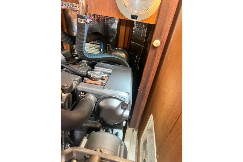 Slide: The Image of Engine compartment of a 1999 Hunter 380 sailboat, showcasing mechanical components and wiring. - 83