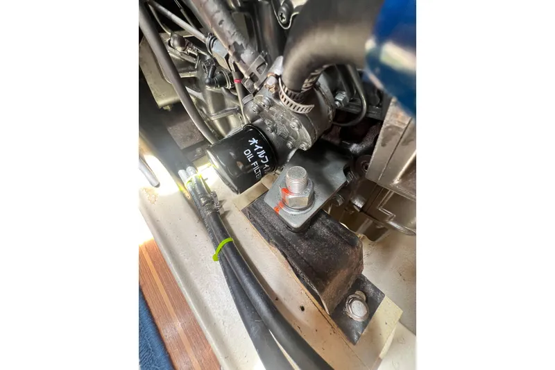 Slide: The Image of Engine compartment of a 1999 Hunter 380 sailboat, featuring an oil filter and hoses. - 87