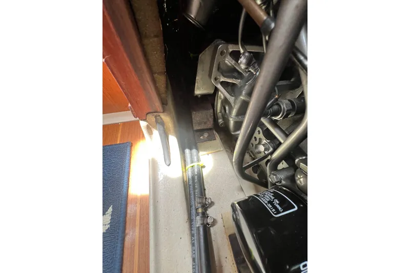 Slide: The Image of Engine compartment of a 1999 Hunter 380 sailboat, showing mechanical components and hoses. - 89