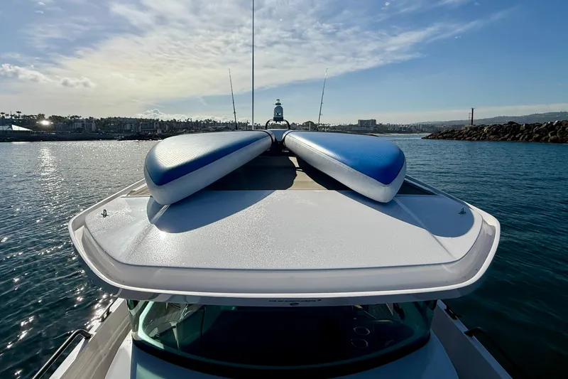 Slide: The Image of 2021 Axopar Brabus 28 Cabin with paddleboards on roof, cruising in sunny coastal waters. - 15