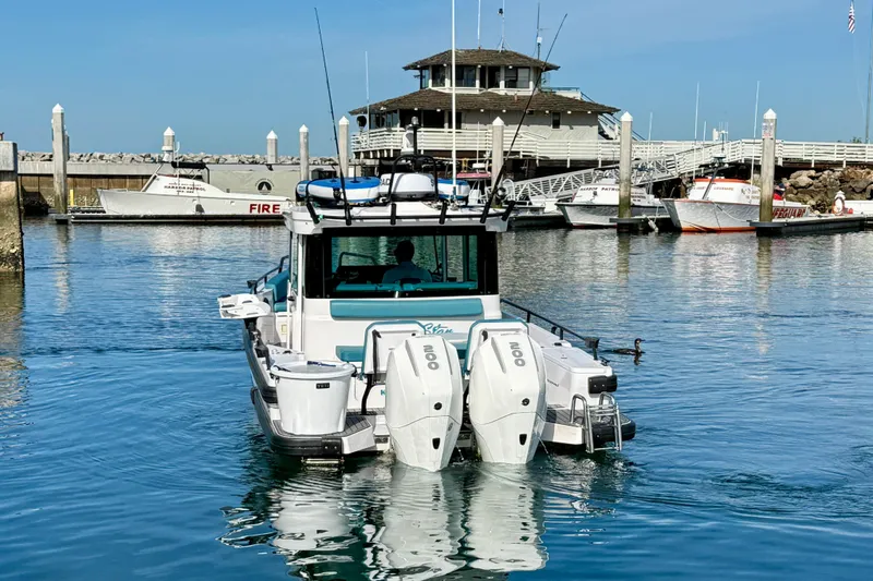 Slide: The Image of 2021 Axopar Brabus 28 Cabin boat docked in a marina with twin engines. - 5