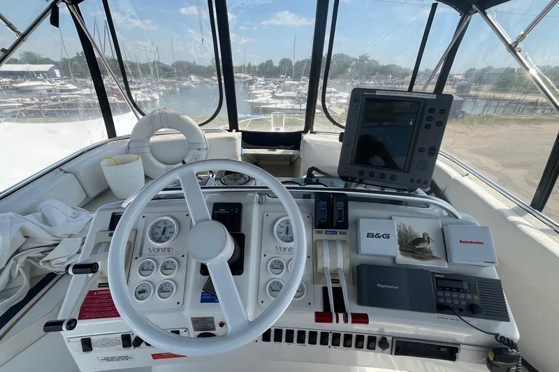 Slide: The Image of 1996 Mainship 40 Sedan Bridge helm with navigation equipment and marina view. - 18
