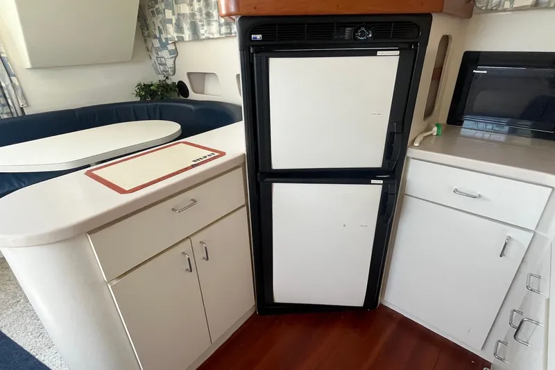 Slide: The Image of 1996 Mainship 40 Sedan Bridge interior with fridge, cabinets, and dining area. - 29