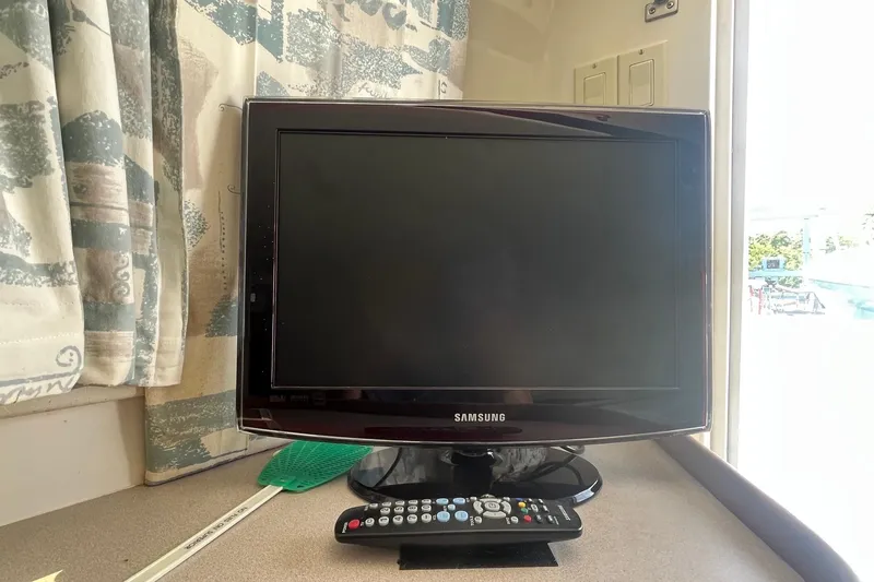 Slide: The Image of Samsung TV with remote on a Mainship 40 Sedan Bridge, 1996 model. - 35