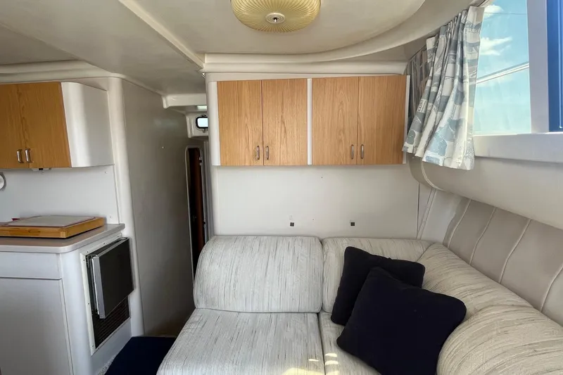 Slide: The Image of Interior of 1996 Mainship 40 Sedan Bridge with sofa, cabinets, and window curtains. - 36